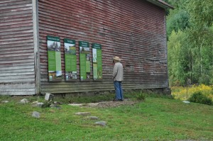 man looking at sign on barn