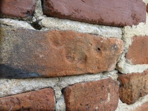 This handprint on one of the bricks of the wall surrounding the old campus was very likely made by a slave.  Photo:  Slavery at South Carolina College team.