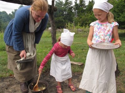 Young visitors to the National Colonial Farm learn the colonial skill of making apple butter from bruised apples. This weekend Green History programming is paired with a current-day exhibit about the problem of food waste (another contributor to global warming). Photo courtesy of the author.
