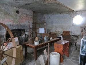 The kitchen, stripped of its modern remodeling. Just behind the spinning wheel is the drop-leaf dining table covered in canvas. (Photo courtesy of Annie Muirhead.)
