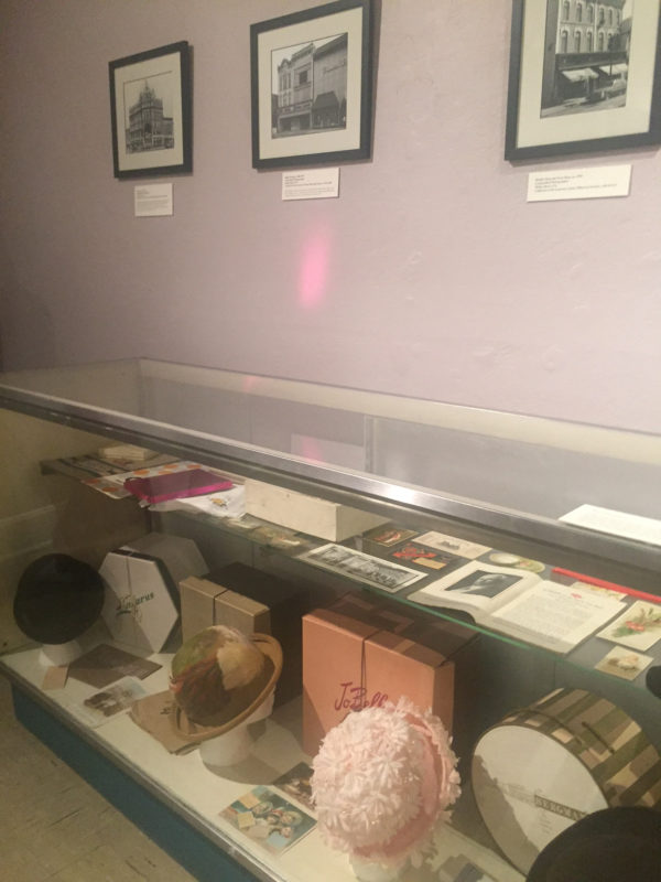 This images features a museum case that is displaying hats with hat boxes and store packaging from Luzerne County, PA, in the “Let’s Go Shopping!” exhibition, Fall 2018, all items collection of the Luzerne County Historical Society.