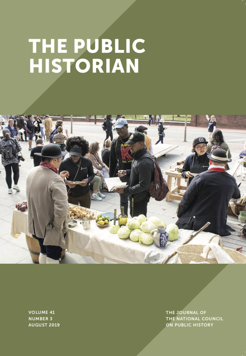 This image is a detail of the cover of the 41.3 (August 2019) issue of The Public Historian. The cover features a green ground and a photograph of costumed interpreters speaking with the public outside. The interpreters are wearing eighteenth-century dress and are surrounded by produce such as cabbage and limes.