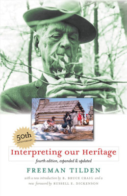 This is an image of the 50th-anniversary cover of Tilden's book Interpreting our Heritage. It includes a green-toned photograph of Tilden outside, a full-color photograph of Revolutionary war-era soldiers outside near log buildings and a fire in the winter, and the book's title and author information.