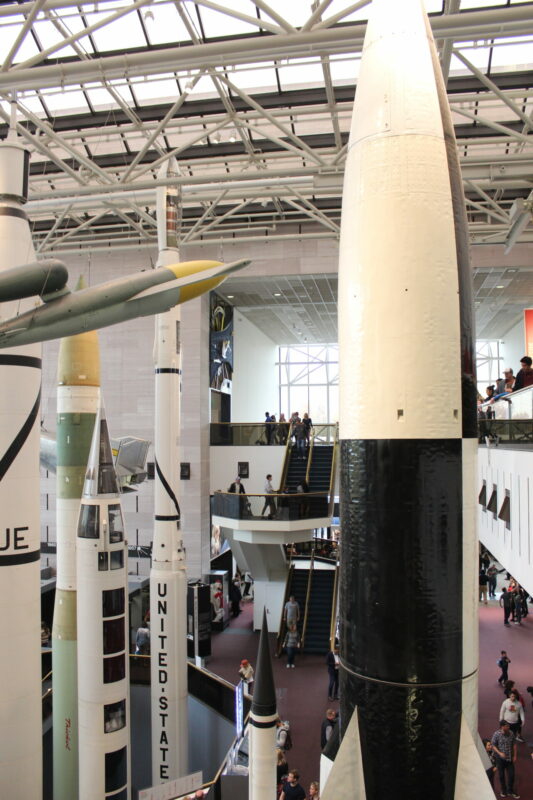 This photo depicts the Smithsonian's ICBM gallery. at least six upright missiles are visible in a very large gallery.