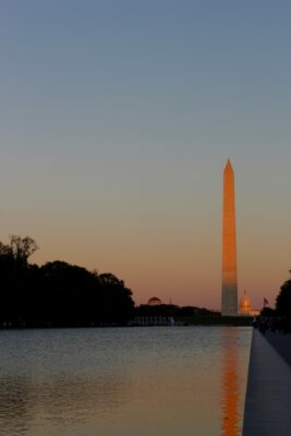 This photo depicts the Washington Monument at dusk with the monument reflected in the Reflecting Pool.