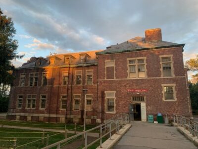 A three-story brick building at dusk.