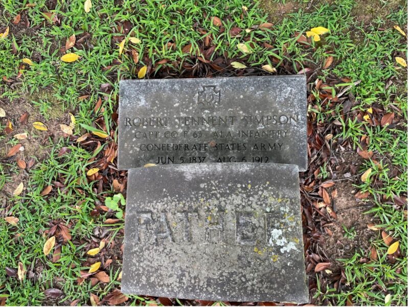 Image of two small rectangular stones lying flat in the grass. Engraved on one stone is the Southern Cross of Honor. Under the cross are the words "Robert Tennent Simpson, Capt. Co. F 63 Ala Infantry, Confederate States Army, June 5, 1837-Aug 6, 1912." The bottom stone simply reads "Father."