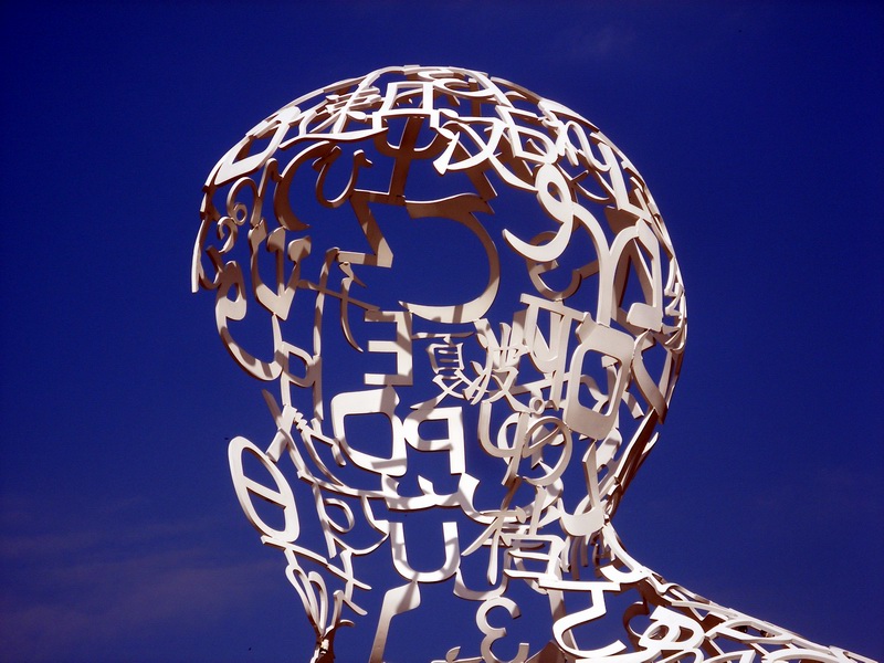 A figure of a human head constructed from interconnected letters and numbers. 