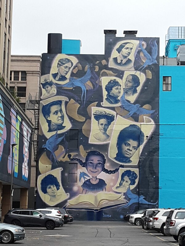This image depicts a mural of ten black and white portraits of women.