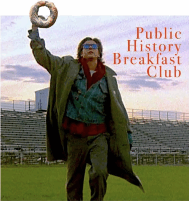Image of a man wearing sunglasses and a large green trenchcoat (actor Judd Nelson) walking on grass through an empty high school football stadium. He is raising his right fist, and holding a large Montreal bagel; the words "Public History Breakfast Club" (in red font) appear the sky. It is an altered image using Photoshop.